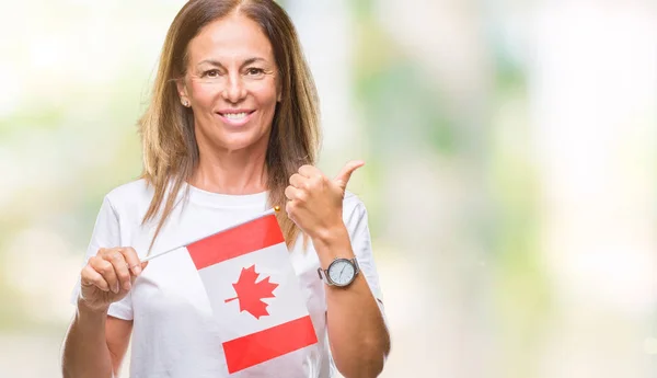 中年西班牙妇女拿着加拿大国旗在孤立的背景高兴与灿烂的微笑做确定的标志 用手指竖起大拇指 优秀的标志 — 图库照片