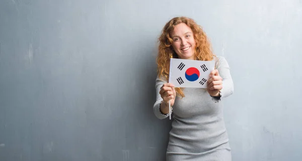 Joven Pelirroja Sobre Pared Grunge Gris Sosteniendo Bandera Corea Del —  Fotos de Stock