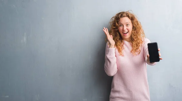 Jonge Roodharige Vrouw Grijs Grunge Wall Weergegeven Smartphone Scherm Erg — Stockfoto