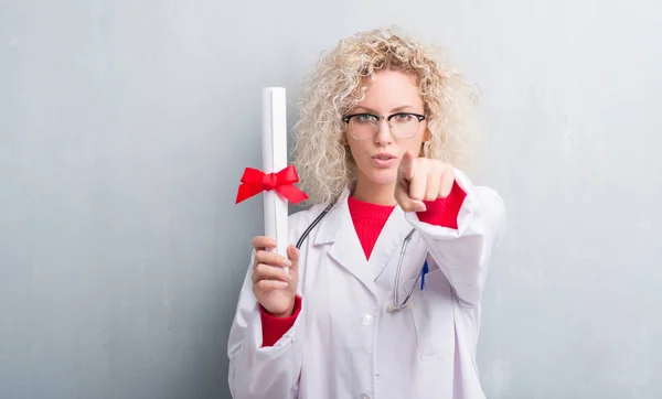 Junge Blonde Ärztin Über Grunzgraue Wand Die Mit Dem Finger — Stockfoto