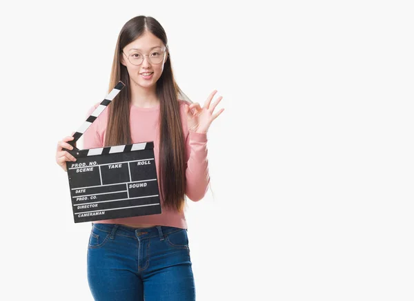 Young Chinese Woman Isolated Background Holding Clapper Doing Sign Fingers — Stock Photo, Image