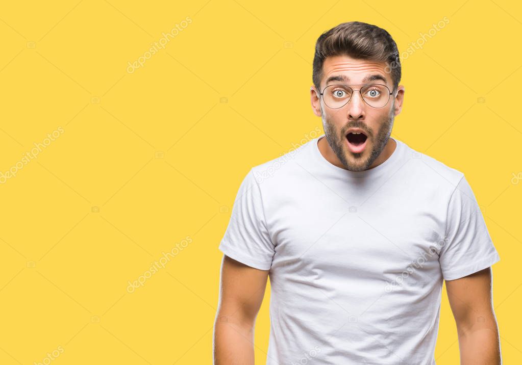 Young handsome man wearing glasses over isolated background afraid and shocked with surprise expression, fear and excited face.