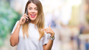 Genç güzel kadın konuşma arama Smartphone sürpriz yüz işaret parmağı kendini izole arka plan üzerinde kullanma