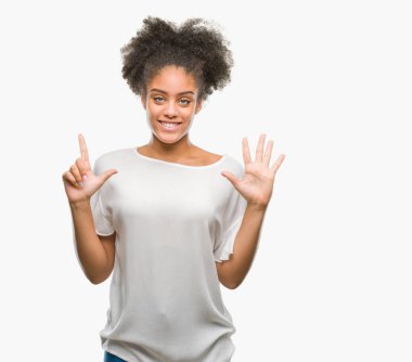 Genç afro Amerikan kadın gösterilen ve parmakları ile işaret izole arka plan yüzünden kendinden emin ve mutlu gülümseyerek süre yedi numara.