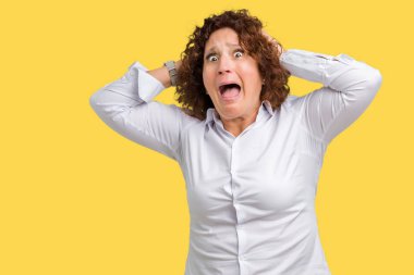 Güzel orta ager üst düzey businees kadın üzerinde arka plan deli izole ve baş, korkuyor ve açık ağzı ile şok sürpriz elleriyle korkuttu