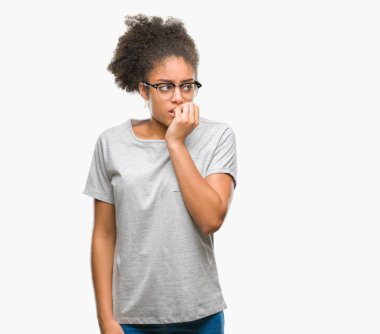 Stresli ve gergin elle çivi ısırma ağzına bakarak izole arka plan üzerinde gözlük takan genç afro Amerikalı kadın. Anksiyete sorunu.