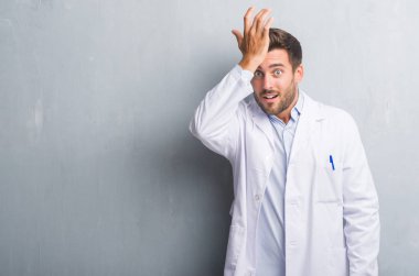 Yakışıklı genç profesyonel adam kafasına hata için beyaz bir el ile sürpriz palto giyiyor gri grunge duvarın üzerinden hata hatırlıyorum. Unuttum, kötü bellek kavramı.