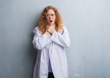 Genç redhead doktor kadın gri grunge duvar bir ceket bağırarak giyen ve çünkü boğmak acı kendi ellerimle öldürürüm. Sağlık sorunu. Yaralarından ve intihar kavramı.