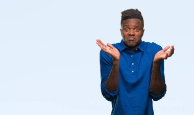Afrikalı-Amerikalı genç izole arka plan clueless ve şaşkın bir ifadeyle kollar ve eller ortaya çıkar üzerinden. Şüphe kavramı.