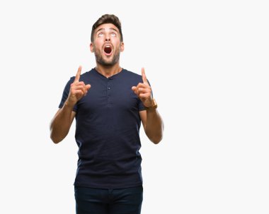 Yakışıklı delikanlı izole arka plan üzerinden hayran ve yukarıya bakıp parmakları ile işaret şaşırttı ve silah kaldırdı.