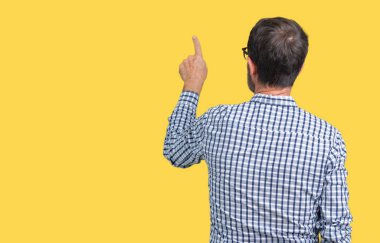 Yakışıklı orta yaş zarif komuta sizde gözlük izole üzerinden geriye doğru arkasında parmak eliyle işaret Posing arka plan