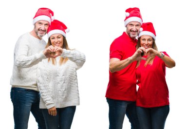 Kolaj orta yaş olgun güzel çift Noel şapka içinde gülümseyen beyaz izole arka plan üzerinde kalp simgesi ve elleriyle şekil gösteren seviyorum. Romantik kavramı.