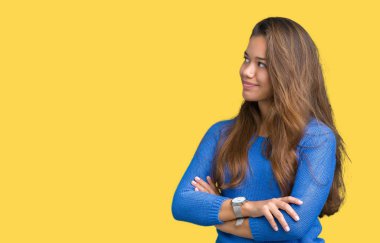 İkna ve kendine güvenen genç güzel esmer kadın tarafına silahlarla seyir gülümseyen izole arka plan üzerinde mavi kazak giyiyor geçti