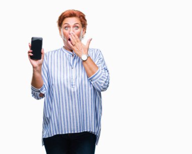 Atrractive üst düzey beyaz Kızıl saçlı kadın gösteren smartphone ekran üzerinde izole arka kapak ağız elle hata, korku, sessizlik içinde gizli kavramı korkmuş ifade için utanç ile şok