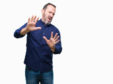 Şokta bağırarak orta yaş ağarmış üst düzey adam izole arka plan korkuyor ve korku ifade dur hareketi el ile ile çok korkmuş. Panik kavramı.