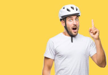 Genç yakışıklı adam başarılı fikirle izole arka plan işaret parmağı üzerinde bisikletçi Güvenlik kask giyiyor. Çıktıktan ve mutlu. Bir numara.