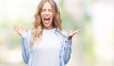 Kızgın ve silah ile başarı için deli kutluyor izole arka plan üzerinde sarışın güzel genç kadın kaldırdı ve heyecanlı çığlık gözler kapalı. Kazanan kavramı