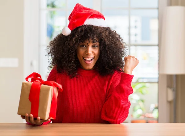 Africano Americano Mulher Segurando Presente Vestindo Natal Chapéu Vermelho Gritando — Fotografia de Stock