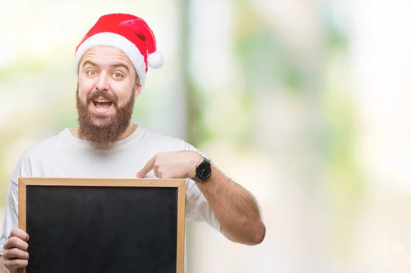 Young Caucasian Hipster Man Wearing Christmas Hat Holding Blackboard Isolated — Stock Photo, Image