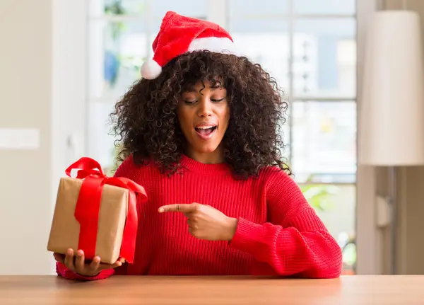 Africano Americano Mulher Segurando Presente Vestindo Natal Chapéu Vermelho Muito — Fotografia de Stock