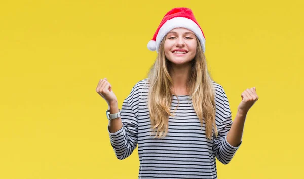 上孤立した背景を祝うクリスマスの帽子をかぶって若い美しいブロンドの女性驚いて腕を上げると成功のため驚くし 目を開きます 勝者の概念 — ストック写真