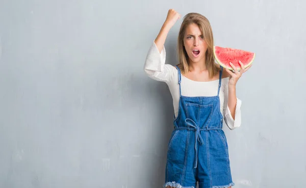 Mulher Bonita Sobre Grunge Parede Cinza Comer Melancia Irritado Frustrado — Fotografia de Stock