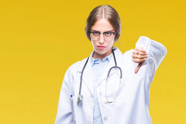 Beautiful young blonde doctor woman wearing medical uniform over isolated background looking unhappy and angry showing rejection and negative with thumbs down gesture. Bad expression.