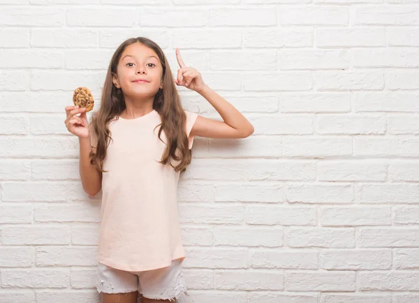 Young Hispanic Kid White Brick Wall Eating Chocolate Chips Cooky — Stock Photo, Image