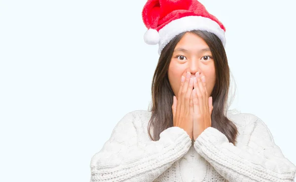 年轻的亚洲妇女戴着圣诞帽在孤立的背景震惊覆盖嘴与手的错误 秘密概念 — 图库照片