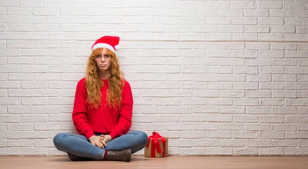 Young Redhead Woman Sitting Brick Wall Wearing Christmas Hat Depressed — Stock Photo, Image