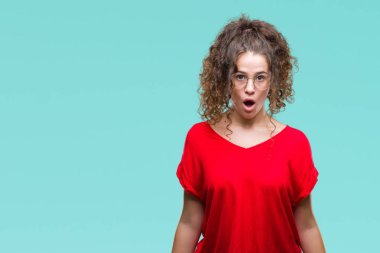 Güzel esmer kıvırcık saçlı Genç kız üzerinde gözlük takan arka plan korkuyor ve şok sürpriz ifade, korku ve heyecan yüz ile izole.