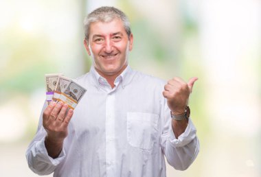 Yakışıklı komuta sizde para demet işaret ve başparmak kadar mutlu yüz gülümseyen tarafı ile gösteren izole arka plan üzerinde tutan