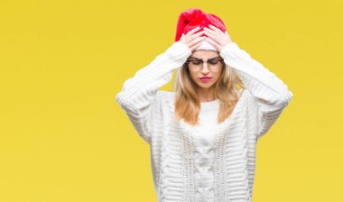 Çünkü çaresiz ve stresli baş ağrısı acı izole arka plan üzerinde Noel şapka giyen genç güzel sarışın kadın ağrı ve migren. Ellerini kafasına.