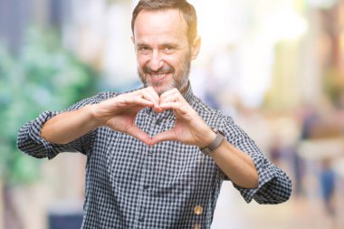 Orta yaş kalp simgesi ve elleriyle şekil gösterilen aşık gülümseyen izole arka plan üzerinde ağarmış komuta sizde. Romantik kavramı.