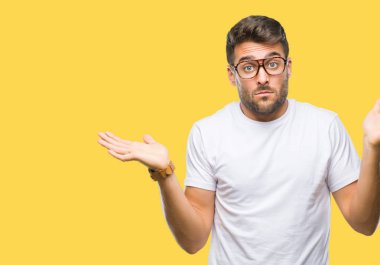 İzole arka plan clueless ve şaşkın bir ifadeyle kollar ve eller kaldırdı üzerinde gözlük takan yakışıklı delikanlı. Şüphe kavramı.