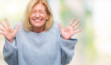 Arka plan deli kutluyor üzerinde kış kazak giyen orta yaş sarışın kadın izole ve crazy arms ile başarı için kaldırdı ve heyecanlı çığlık gözler kapalı. Kazanan kavramı