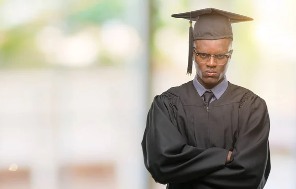 Young graduated african american man over isolated background skeptic and nervous, disapproving expression on face with crossed arms. Negative person.