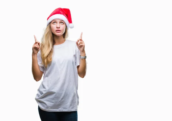 크리스마스 모자를 금발의 그리고 찾고과 손가락으로 가리키는 놀라게 — 스톡 사진