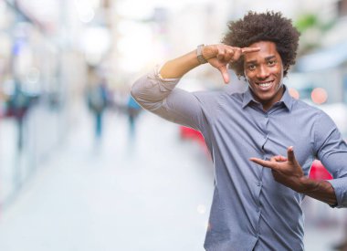 Elle yapma çerçeve ve parmakları ile mutlu yüz gülümseyen izole arka plan üzerinde Afro Amerikalı adam. Yaratıcılık ve Fotoğrafçılık kavramı.