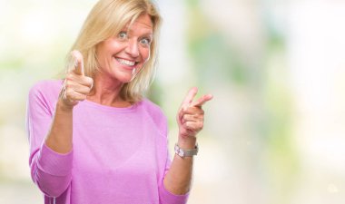 Orta yaş sarışın kadın kamera ile mutlu ve komik yüz için parmakları işaret izole arka plan yüzünden. İyi enerji ve vibes.