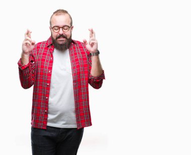 Umut ve gözleri kapalı geçiş parmaklarıyla gülümseyen izole arka plan üzerinde gözlük takan Genç beyaz hipster adam. Şans ve batıl kavramı.