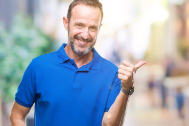 Orta yaş ağarmış komuta sizde seyir ve başparmak yanında yukarıyı mutlu yüz ile gülümseyen izole arka plan üzerinde.