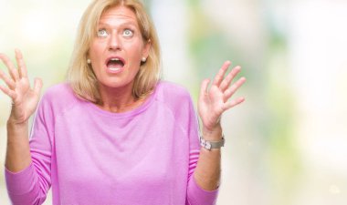 Orta yaş sarışın kadın izole arka plan çılgın ve kızgın bağırarak ve agresif ifade ve silah kaldırdı bağırıyor. Hayal kırıklığı kavramı.