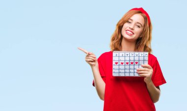 İzole arka plan adet takvim çok mutlu el ve parmak ile tarafına işaret tutan genç güzel kadın