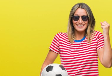 Duygu tezahürat gurur çığlık ve zafer ve başarı çok heyecanlı, kutluyor izole arka plan üzerinde futbol futbol topu tutan genç güzel kadın