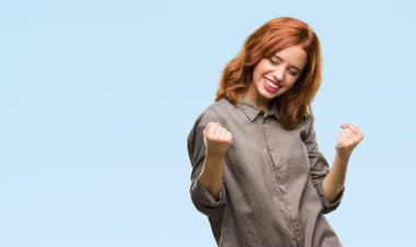 Gülümseyen ve başarı için çığlık genç güzel kadın izole arka plan çok mutlu ve heyecanlı kaldırdı, silah ile kazanan jest yapıyor. Kutlama kavramı.