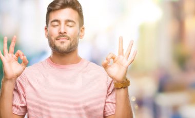 Yakışıklı delikanlı izole arka plan üzerinde dinlenmek ve gülümseyen gözlerle parmak ile meditasyon jest yapıyor kapalı. Yoga kavramı.