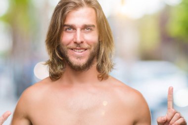 Genç yakışıklı gömleksiz adam uzun saçlı seksi vücut gösterilen ve parmakları ile işaret izole arka plan üzerinde gösterilen 6 kendinden emin ve mutlu gülümseyerek iken numara.