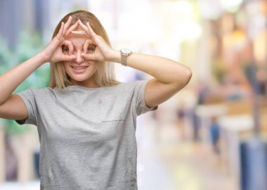 Dilini, parmaklarının arasından baktığını yapışmasını dürbün gibi ok jest yapıyor izole arka plan üzerinde beyaz kadın. Deli ifade.