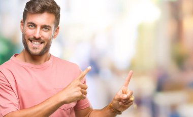 Yakışıklı delikanlı gülümseyen ve iki elleri ve parmakları ile tarafına işaret kamera bakarak izole arka plan üzerinde.